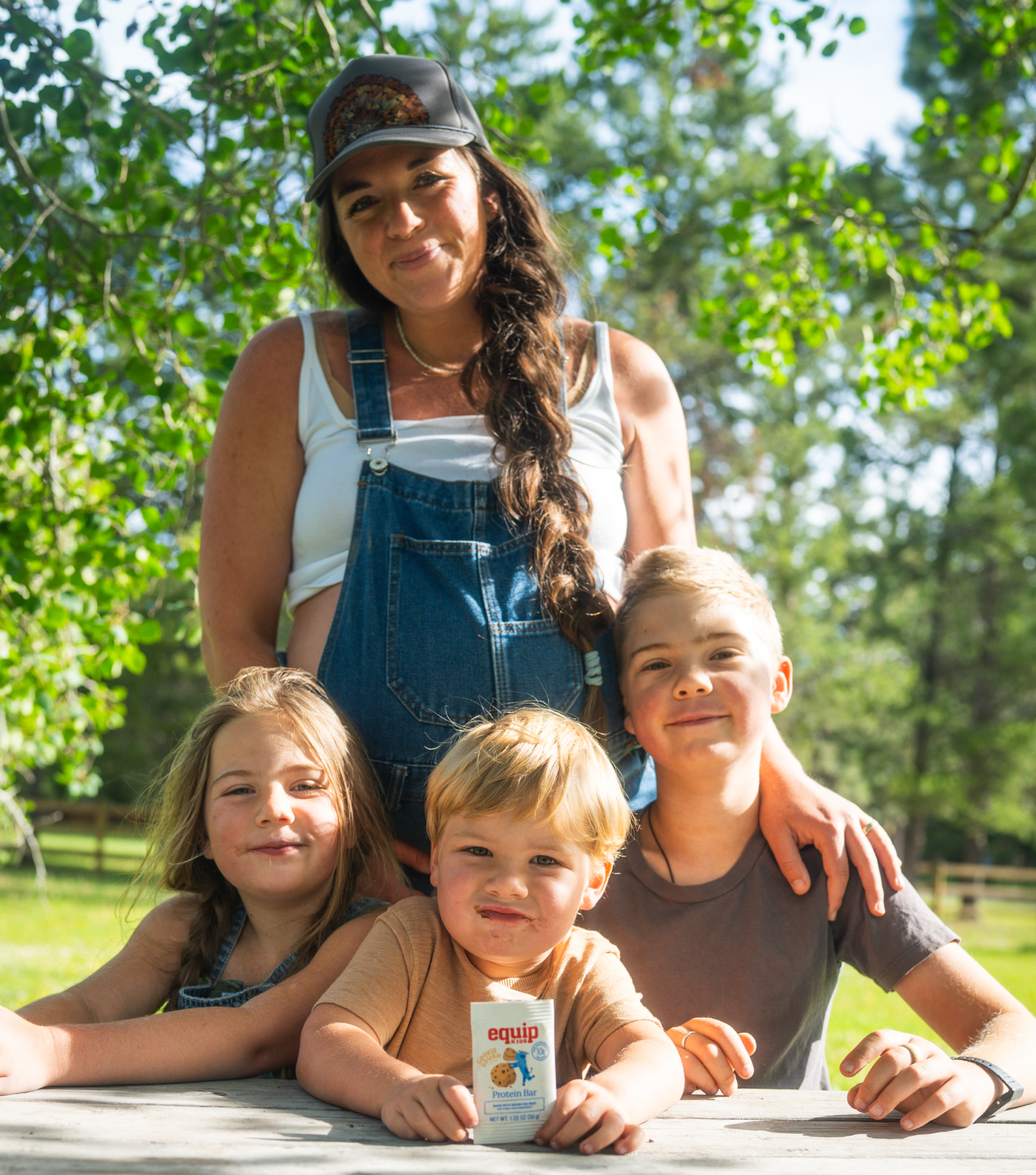 Parent and child sitting in a field sharing a Kids Prime Bar